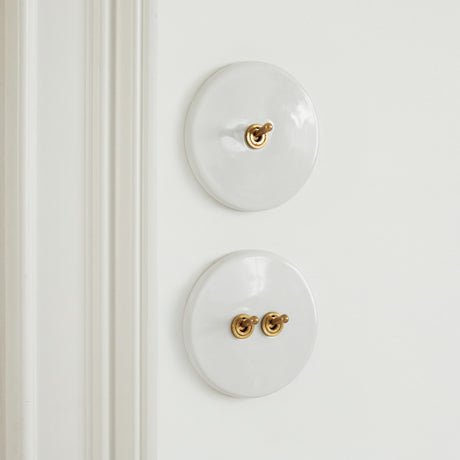Interrupteur blanc porcelaine et laiton
