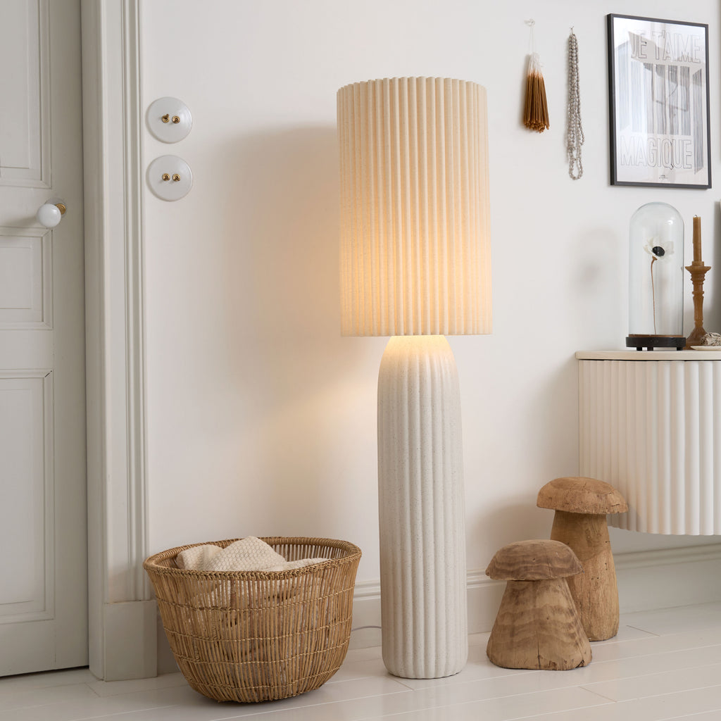 Lampadaire cannelé installé dans un intérieur aux matières et aux teintes naturelles