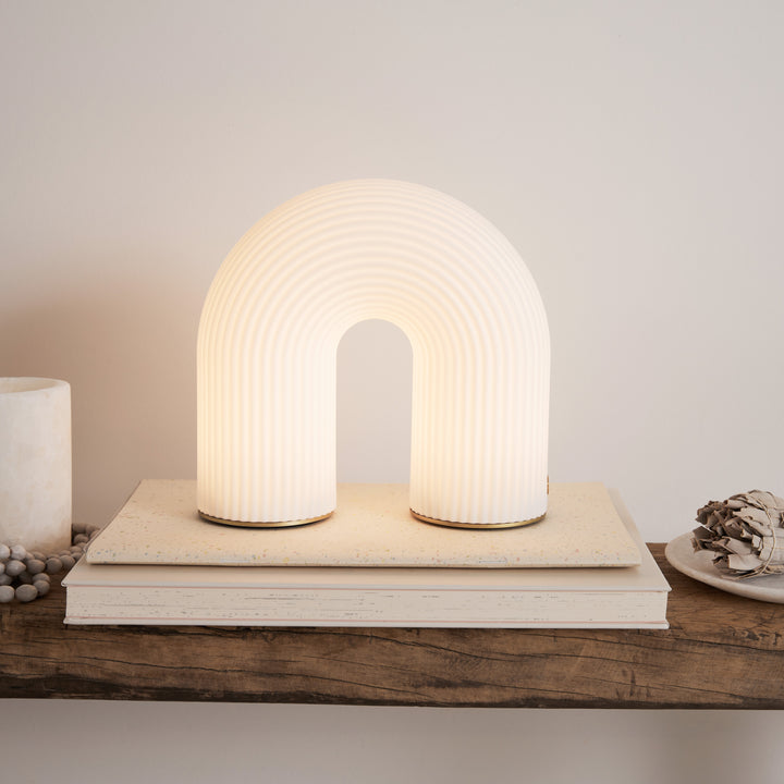 Petite lampe arche sans fil posée sur un meuble ou une étagère