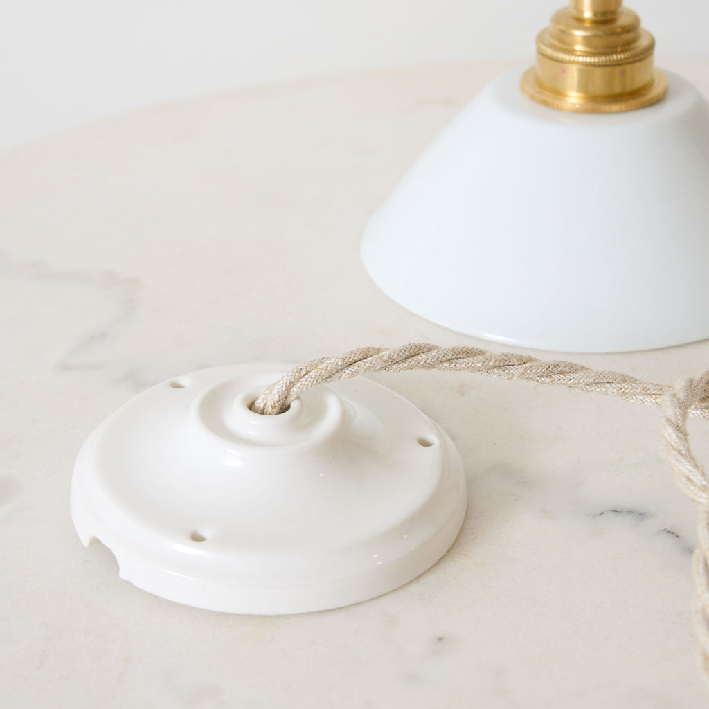Petite suspension en porcelaine blanche et laiton créant un éclairage délicat