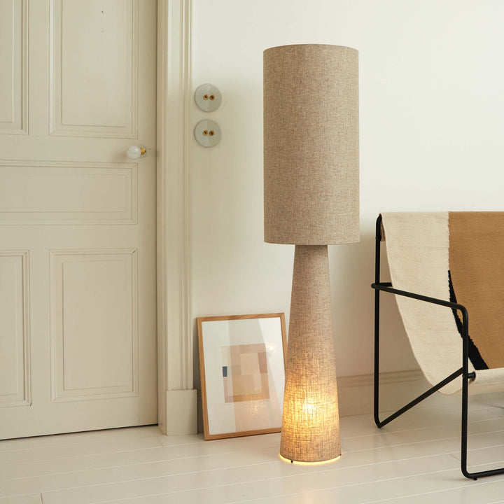 Lampadaire en lin beige installé dans une chambre aux teintes naturelles