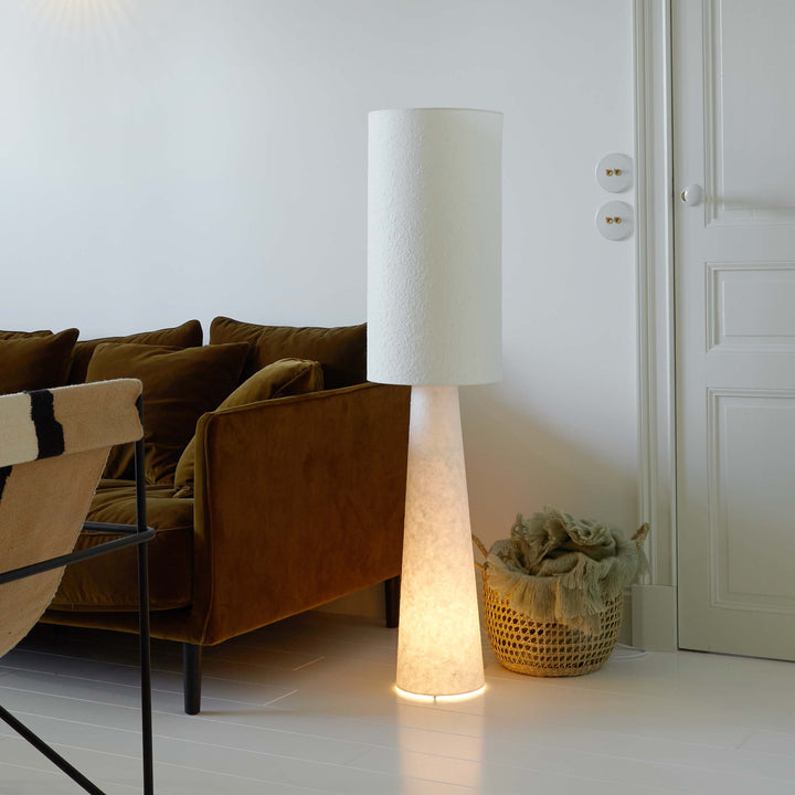 Lampadaire blanc en papier mâché placé dans un angle du salon