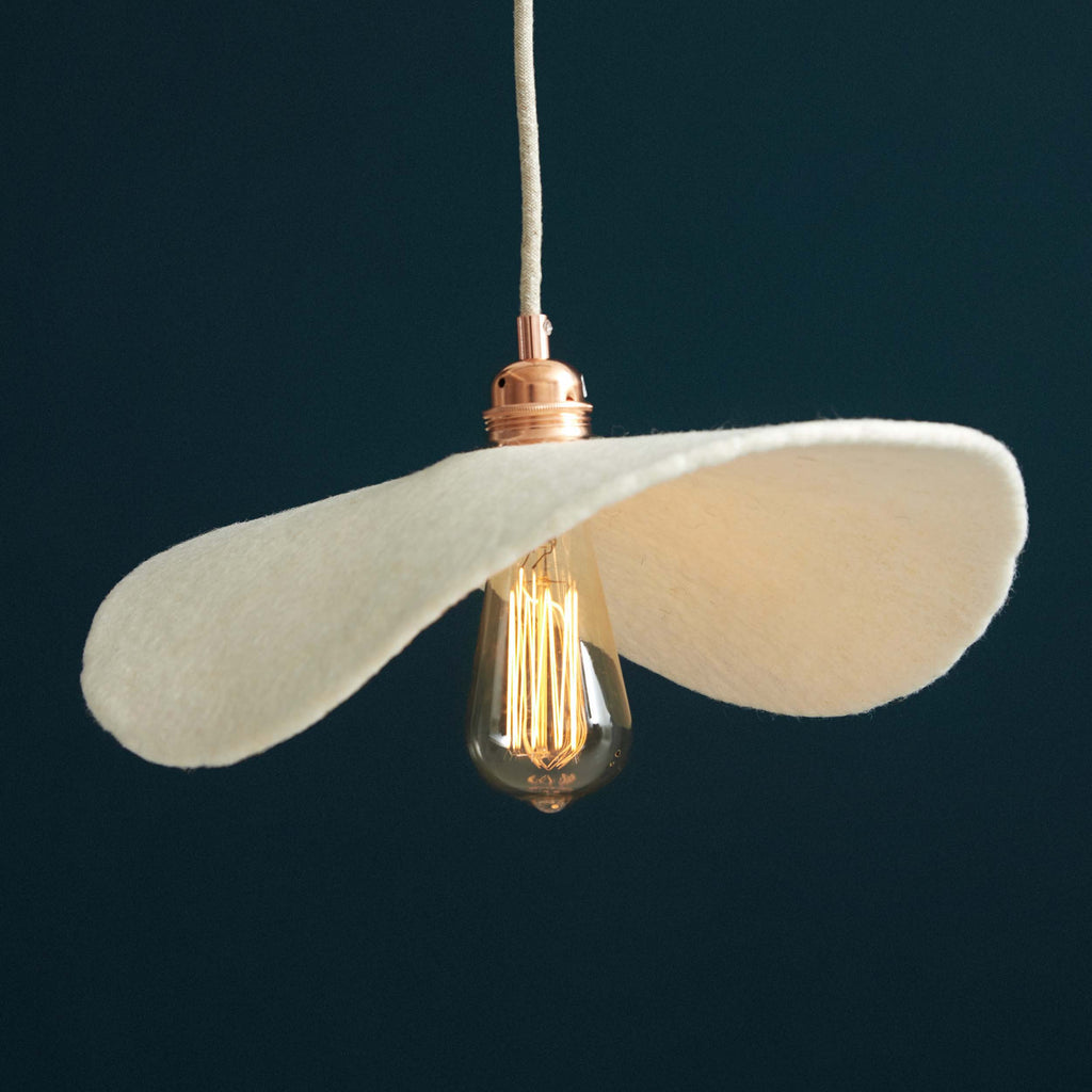 Suspension plate en feutre diffusant une lumière douce dans un intérieur chaleureux